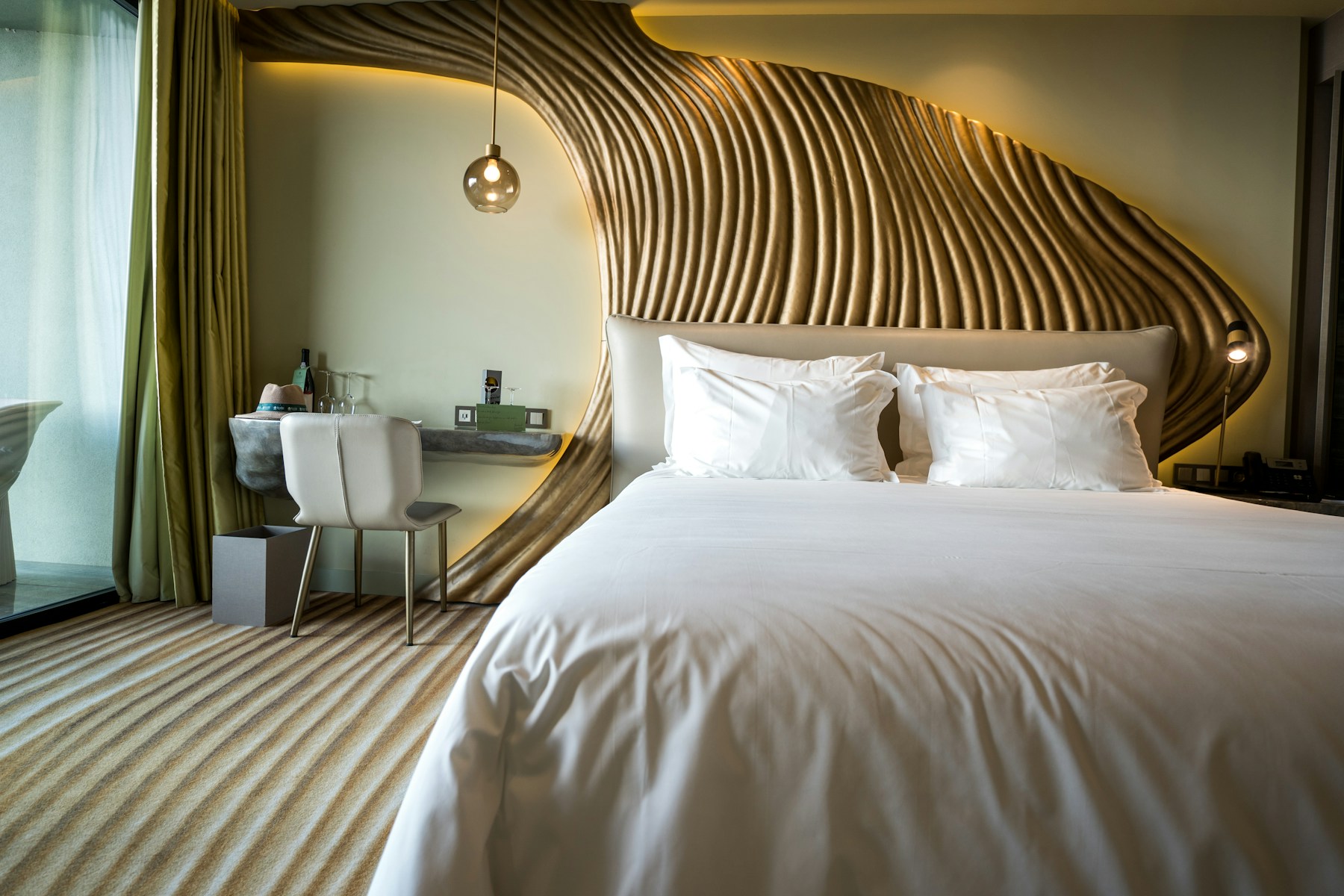 A softly lit premium bedroom with an upholstered bed